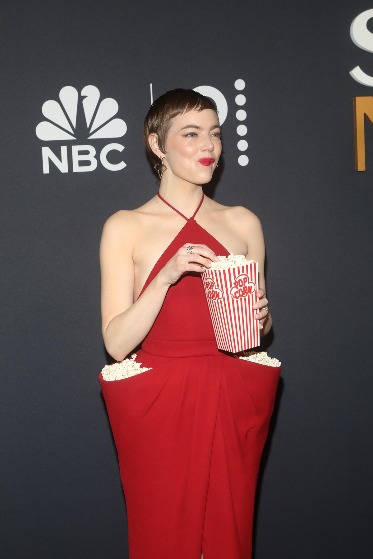 Emma Stone com pipoca em bolsos do vestido em evento do SNL - Metrópoles