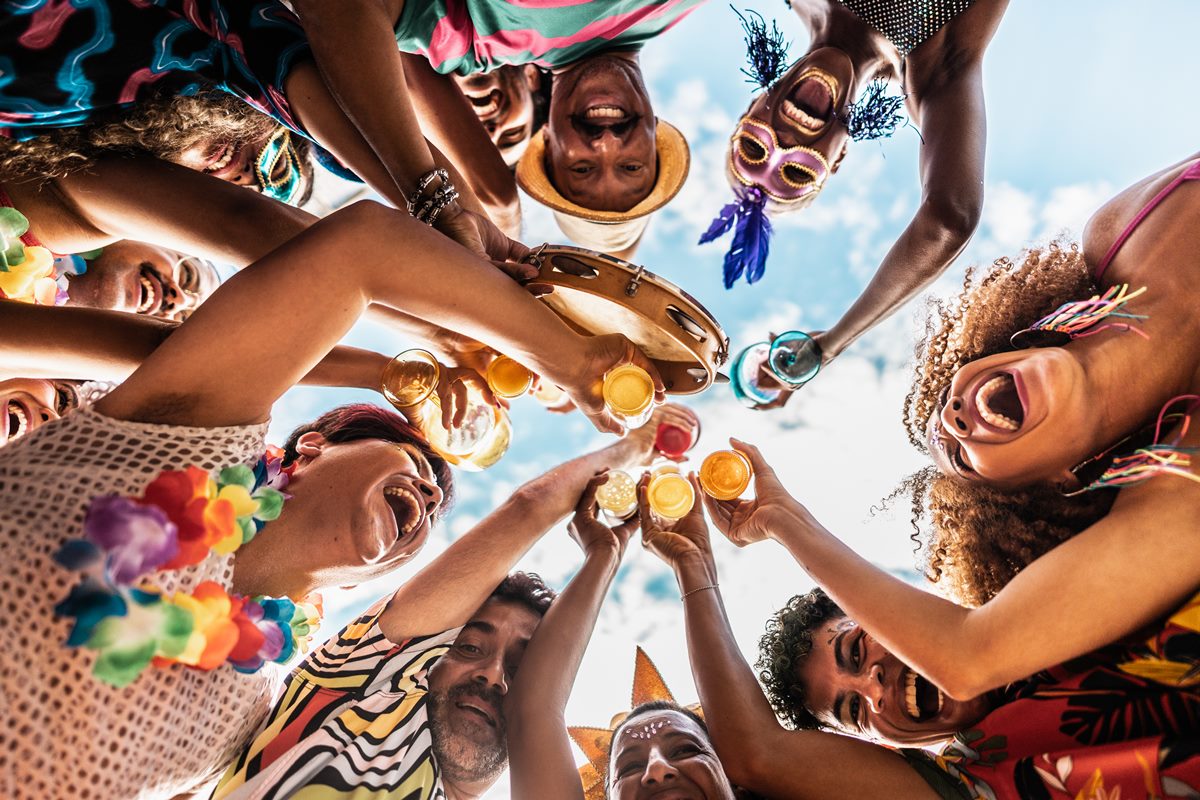 Fotografia mostra, de baixo para cima, grupo de amigos brindando no Carnaval - Metrópoles - álcool
