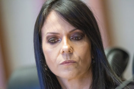 Foto colorida de mulher de cabelo grande e preto em depoimento