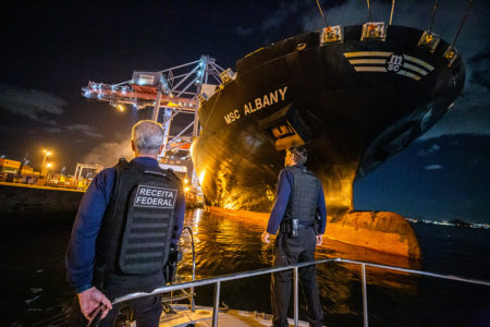 Imagem colorida retrata uma operação da Receita Federal em um navio cargueiro