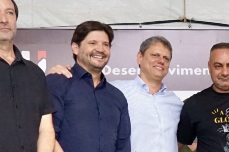 Fotografia colorida mostra André do Prado (PL) e Tarcísio de Freitas (Republicanos) abraçados em evento