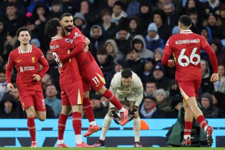 Imagem colorida dos jogadores do Liverpool comemorando - Metrópoles