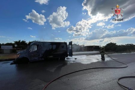 Foto colorida de ambulância com fumaça e bombeiros presentes