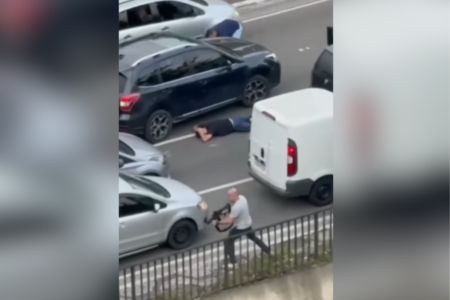 Imagem colorida de homem de camiseta branca com arma na mão e outro homem, de camiseta preta, no chão. Eles são suspeitos de roubar casas em SP - Metrópoles