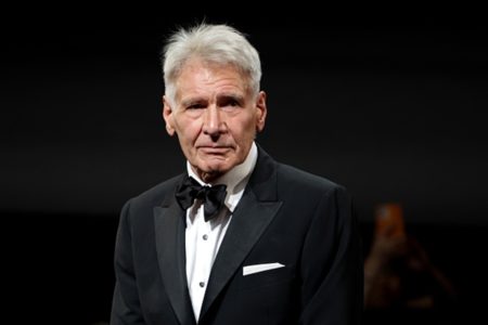Foto colorida do ator Harrison Ford em cerimônia - Metrópoles