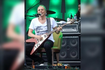 Foto colorida de Tony Belloto tocando em um show da banda Titãs - Metrópoles