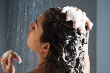 mulher lavando o cabelo no banho