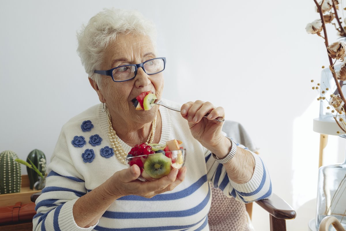 Foto colorida de mulher comendo frutas - Metrópoles