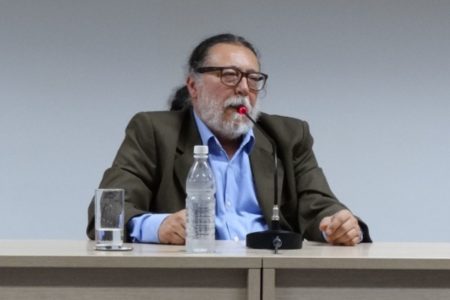 Imagem mostra um homem branco de óculos quadrados e barba branca
