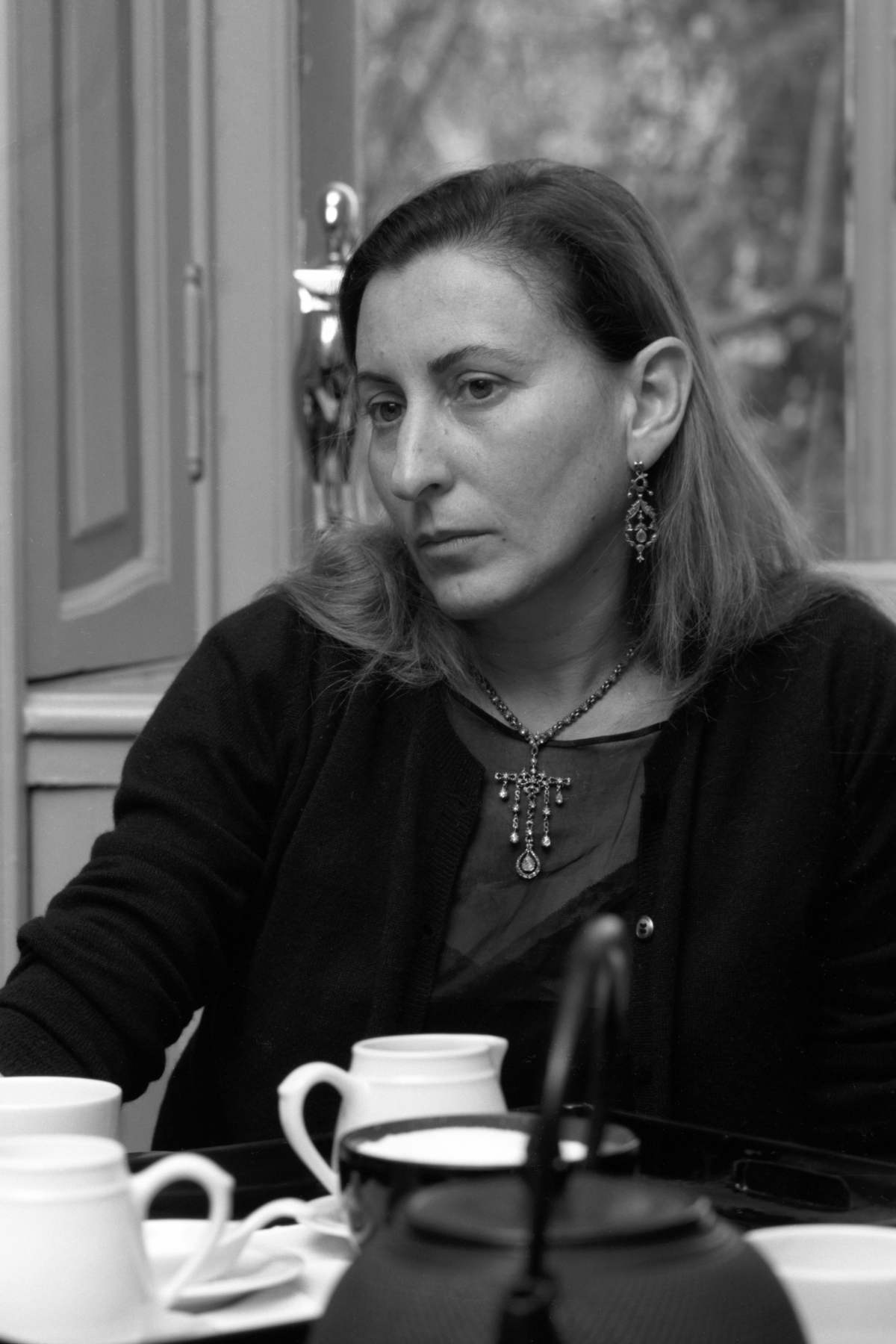A imagem mostra a designer Miuccia Prada sendo entrevistada