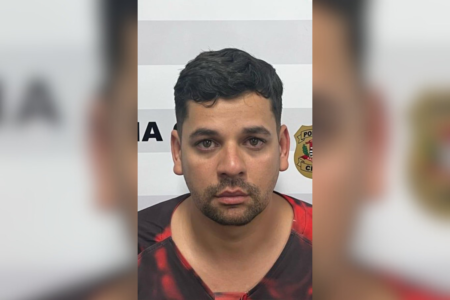 Imagem colorida de um homem branco de barba e bigode, vestindo uma camiseta preta e vermelha - Metrópoles
