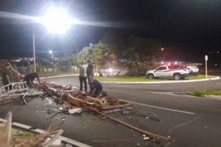 imagem colorida mostra homens olhando torre de transmissão caída em rua de bauru