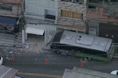 Imagem colorida feita do alto mostra ônibus batido na fachada de duas casas no - Metrópoles
