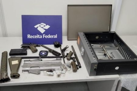 Imagem colorida de peças de armas em cima de uma mesa de inspeção da Receita Federal - Metrópoles