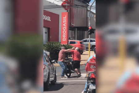 Imagem colorida de dois homens, condutores de um carro e uma motocicleta, trocando socos durante uma briga de trânsito - Metrópoles