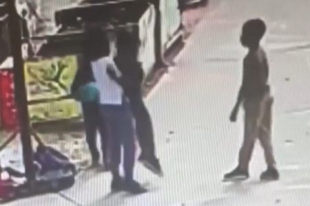 Imagem mostra criança de blusa branca fazendo a manobra de Heimlich em um colega - Metrópoles