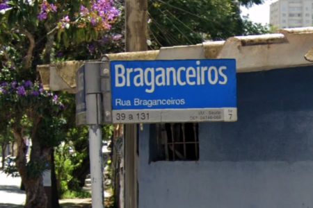 Imagem colorida de placa com nome de rua. Metrópoles