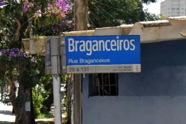 Imagem colorida de placa com nome de rua. Metrópoles