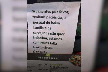 Imagem colorida de um comunicado escrito em papel na bancada de atendimento de um restaurante - Metrópoles