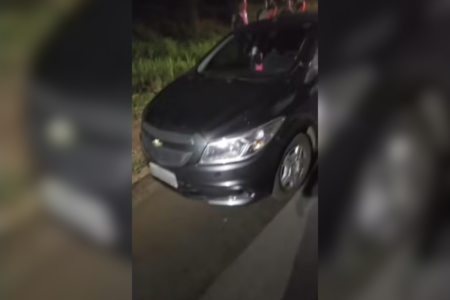 Imagem colorida de um Chevrolet Ônix cinza onde mulher estava