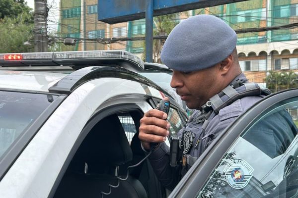 Imagem colorida mostra policial militar falando em rádio - Metrópoles