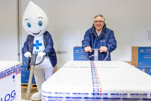 Imagem colorida de Alexandre Padilha com Zé gotinha em entrega de vacinas contra Influenza