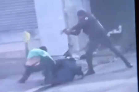 Imagem colorida de PM com arma apontada para homem que reagiu a abordagem policial. Metrópoles