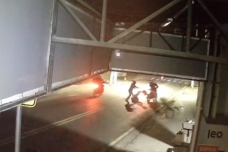 Imagem colorida de suspeito soltando uma moto no chão. Metrópoles