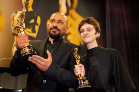 Imagem colorida de Hamdan Ballal e Rachel Szor, vencedores do prêmio de Melhor Documentário por No Other Land