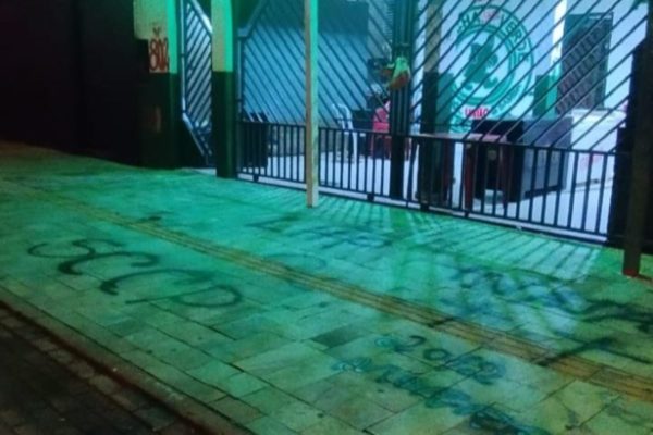 Imagem colorida de uma cabeça de porco pendurada no portão de uma sub-sede da mancha verde - Metrópoles