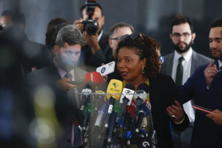 Ministra da Cultura, Margareth Menezes, concede entrevista coletiva no Palácio do Planalto para falar sobre destruição de patrimônio público causada por terroristas bolsonaristas. Ela fala diante de microfones e cercada de autoridades - Metrópoles