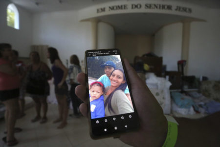 Familiares seguram celular com foto da vítima das chuvas em são Paulo - Metrópoles